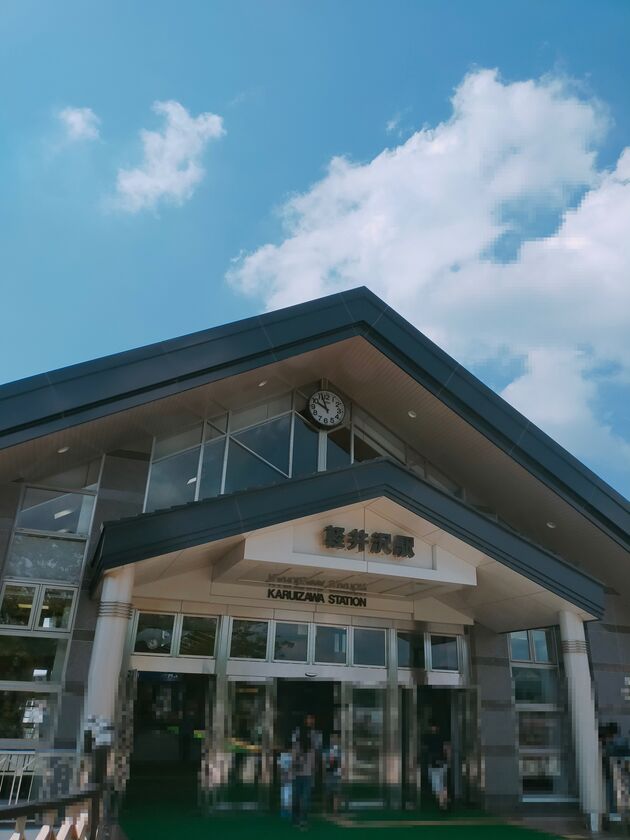 軽井沢駅の駅舎。三角屋根の入口と青空