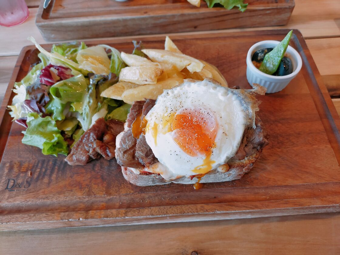 軽井沢・プリンスショッピングプラザで食べたランチ。木のプレートに肉と目玉焼きをのせたパンとサラダ