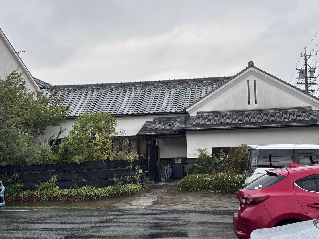 じょあんの外観。瓦屋根と白壁の建物の前に広い駐車場がある