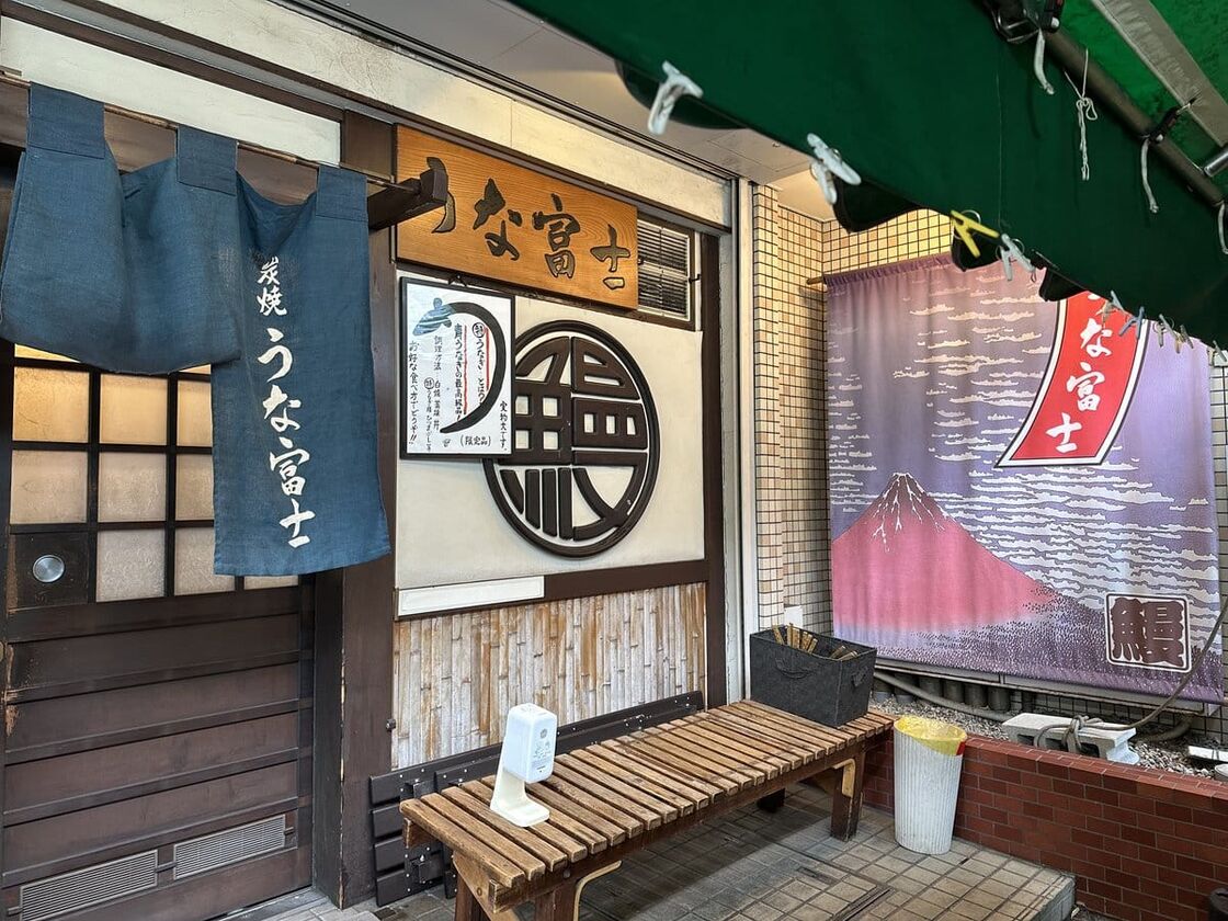炭焼 うな富士 本店の入口。「うな富士」ののれんと赤富士の幕がかかっている