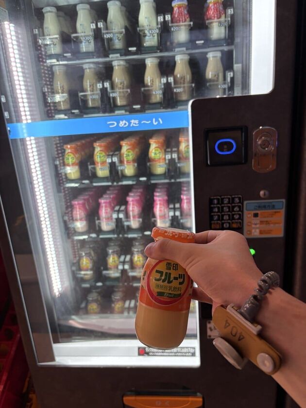自販機から取り出した瓶入りのフルーツ牛乳